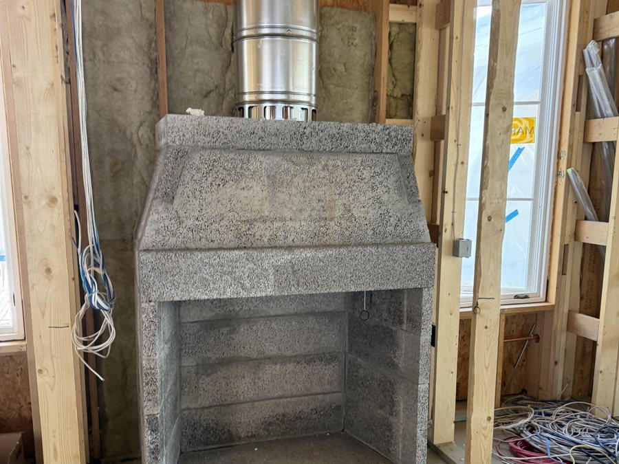A masonry firebox and flue built into a framed wall before the finish goes on