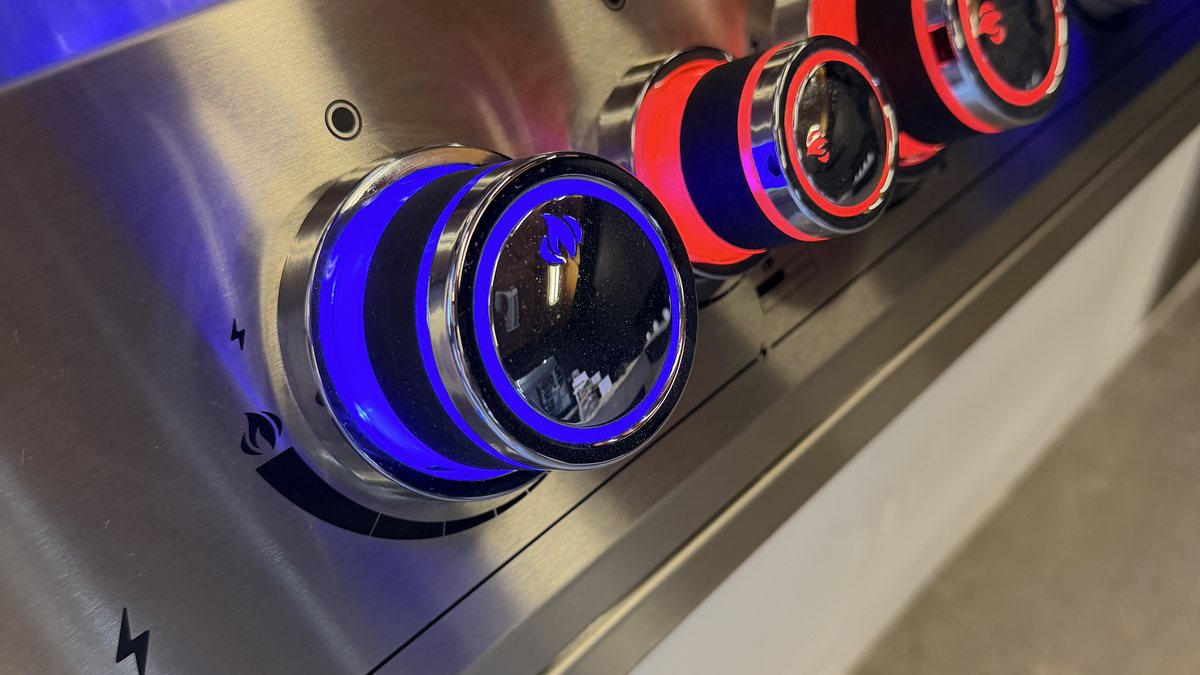 Close up of illuminated control knobs on a stainless built-in grill