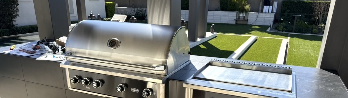 A built-in grill and griddle set into a finished outdoor kitchen island